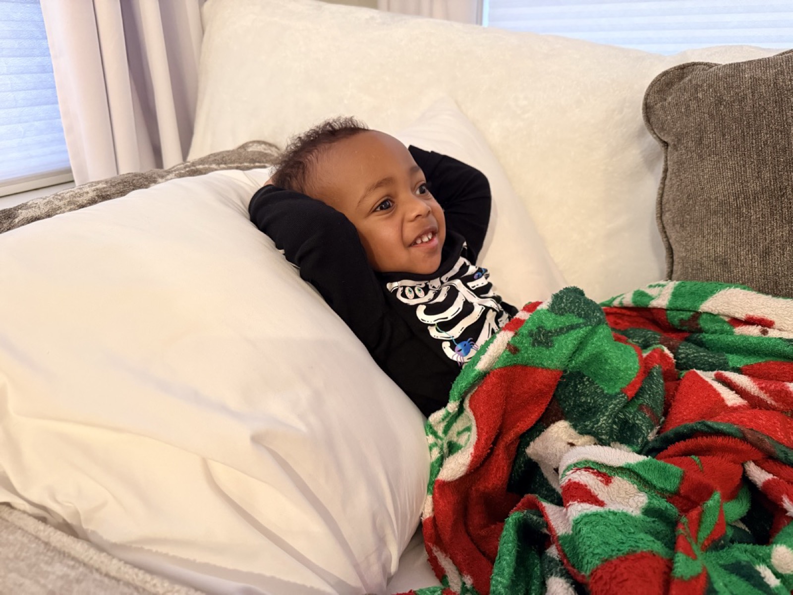 Yohannes smiling on the couch in his skeleton shirt