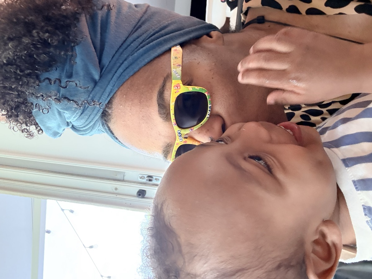 Close-up of mom wearing fun yellow DOTS sunglasses nuzzling baby Yohannes cheek to cheek